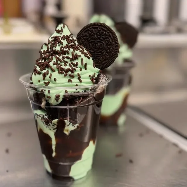 Mint soft serve sundae with an Oreo, chocolate sauce and cookie crumbs